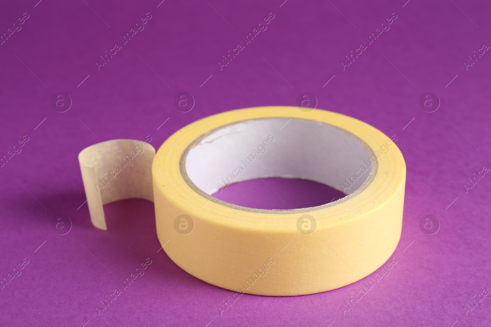 Photo of Roll of masking tape on violet background