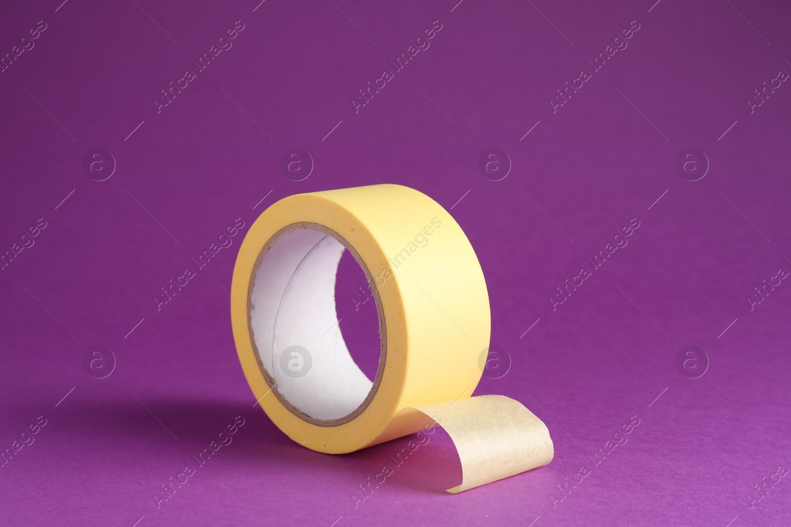 Photo of Roll of masking tape on violet background