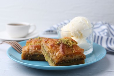 Photo of Tasty baklava with chopped nuts and scoops of ice cream on white table, closeup