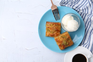 Tasty baklava with chopped nuts, ice cream and coffee on white table, flat lay. Space for text