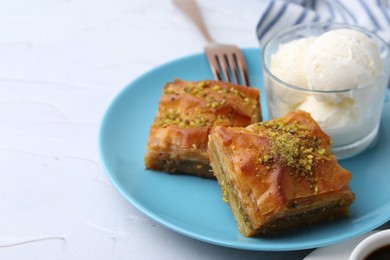 Photo of Tasty baklava with chopped nuts and scoops of ice cream on white table, closeup