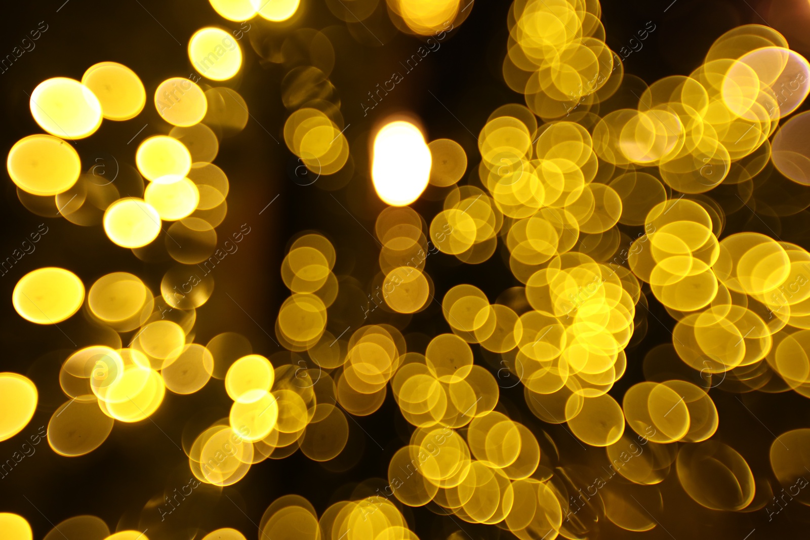 Photo of Blurred view of golden lights on dark background, bokeh effect