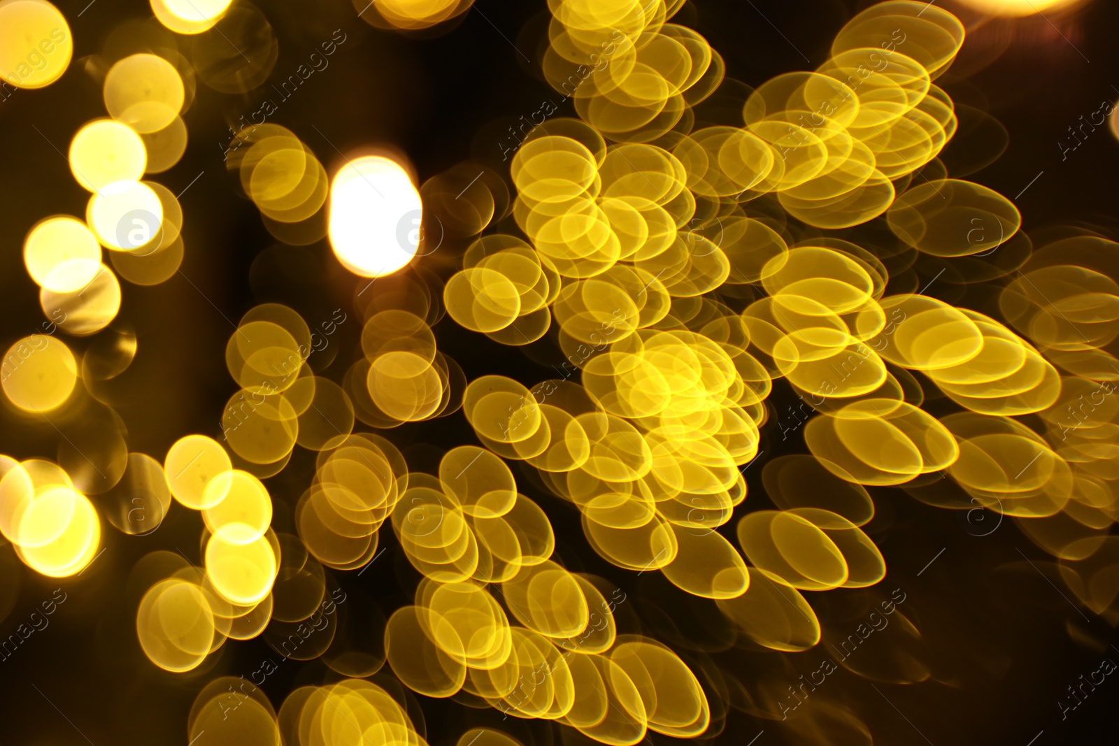 Photo of Blurred view of golden lights on dark background, bokeh effect