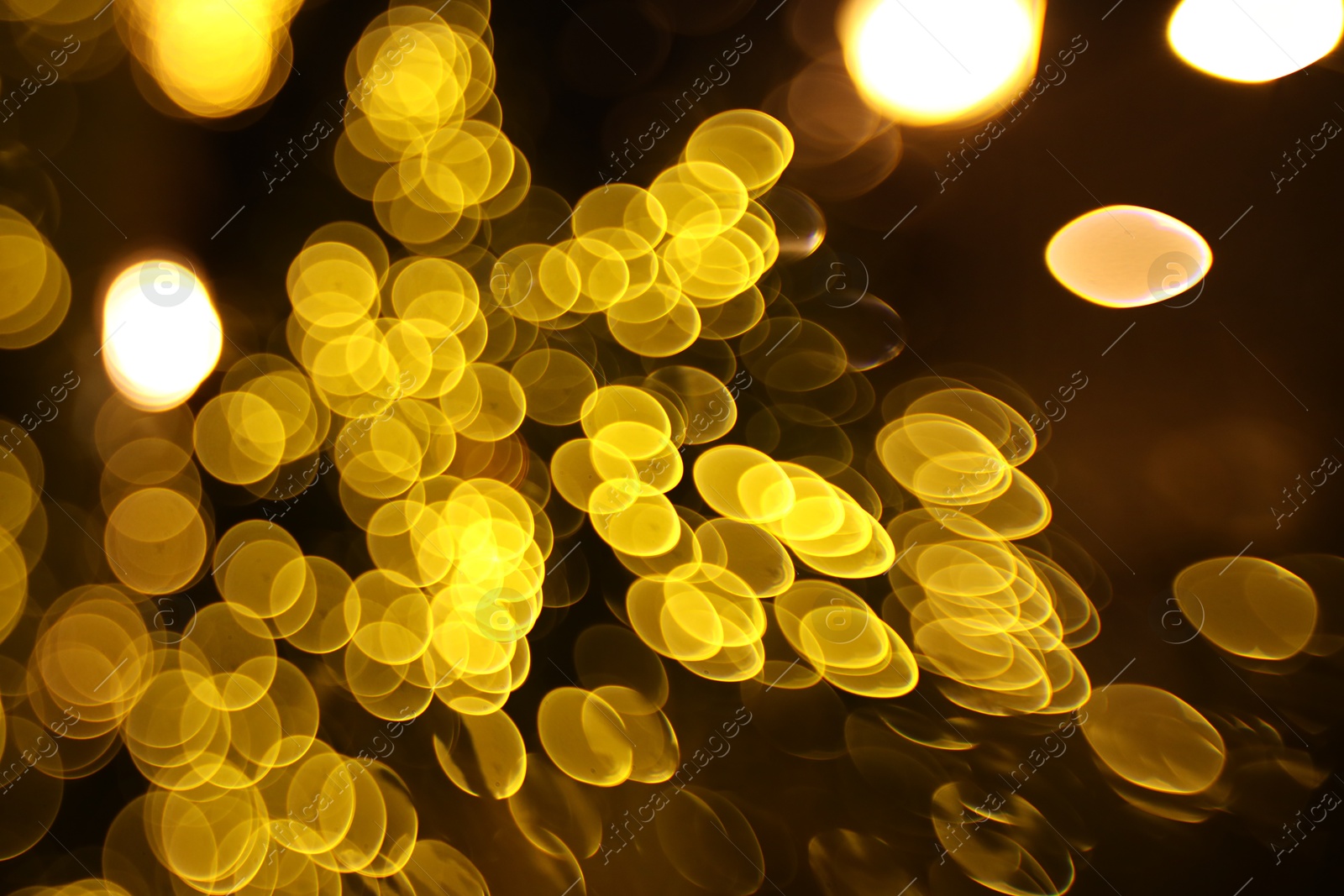 Photo of Blurred view of golden lights on dark background, bokeh effect