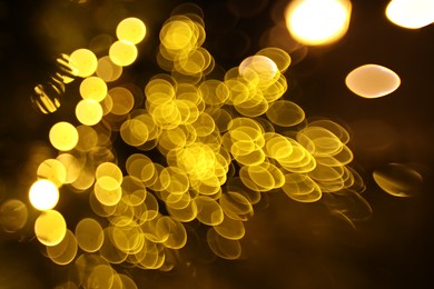 Photo of Blurred view of golden lights on dark background, bokeh effect