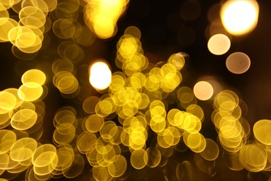 Photo of Blurred view of golden lights on dark background, bokeh effect