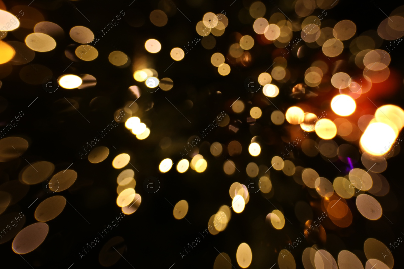 Photo of Blurred view of golden lights on dark background, bokeh effect