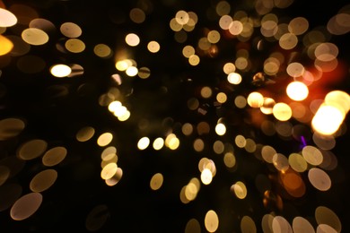 Photo of Blurred view of golden lights on dark background, bokeh effect