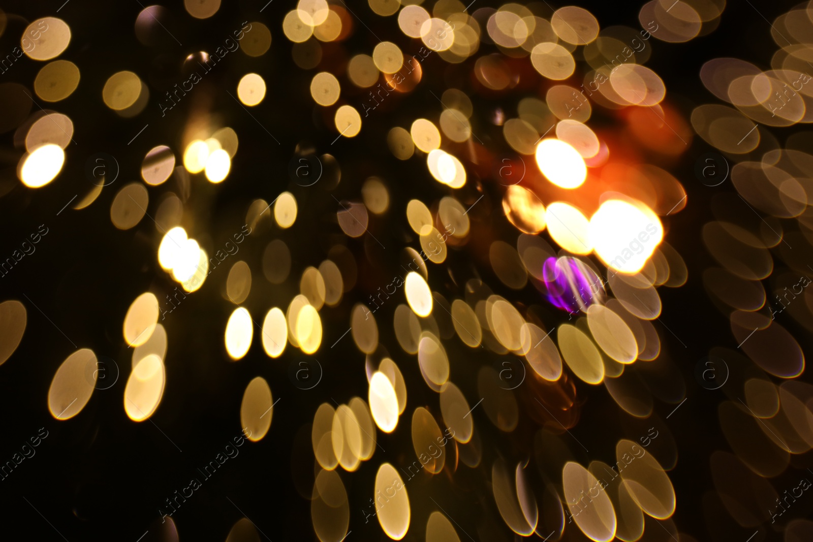 Photo of Blurred view of golden lights on dark background, bokeh effect