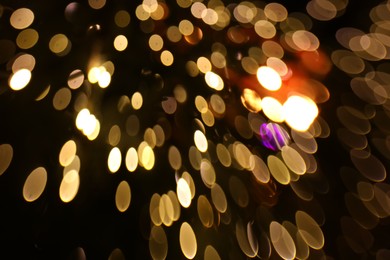 Photo of Blurred view of golden lights on dark background, bokeh effect