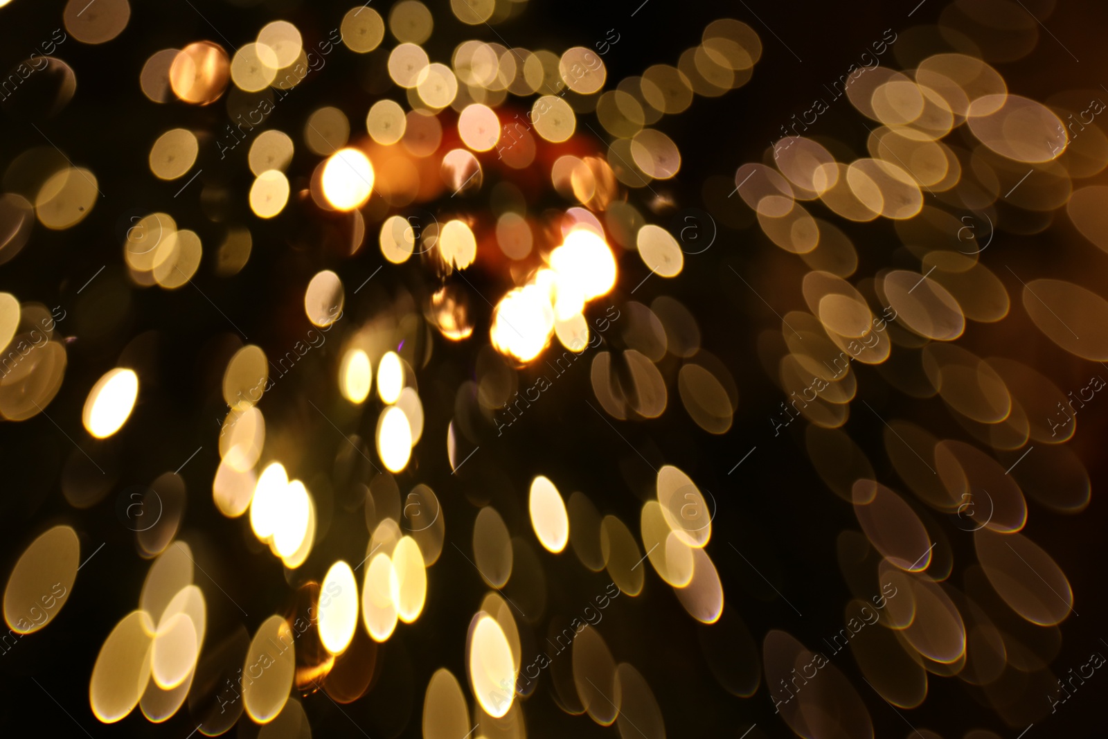 Photo of Blurred view of golden lights on dark background, bokeh effect