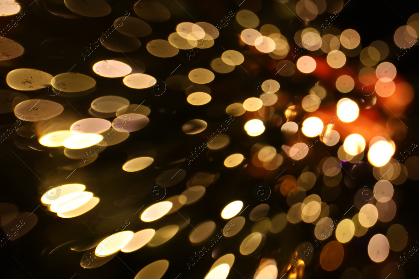 Photo of Blurred view of golden lights on dark background, bokeh effect