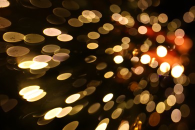 Photo of Blurred view of golden lights on dark background, bokeh effect