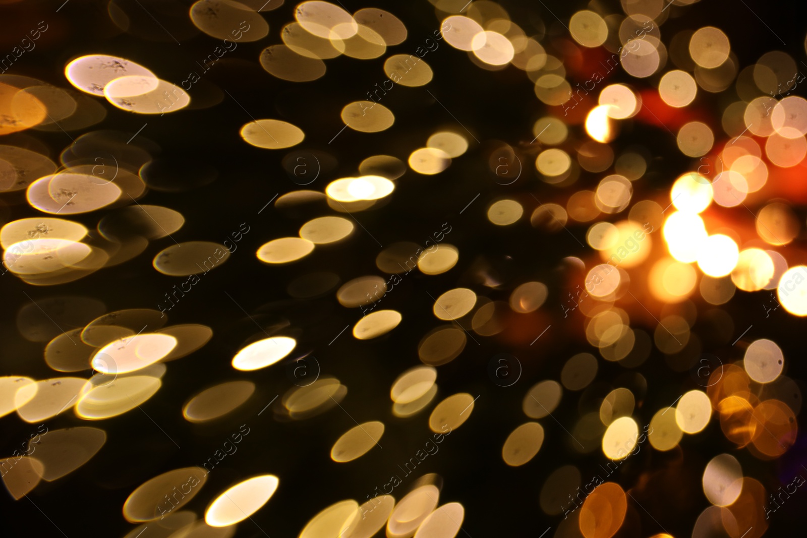 Photo of Blurred view of golden lights on dark background, bokeh effect