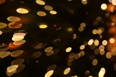 Photo of Blurred view of golden lights on dark background, bokeh effect