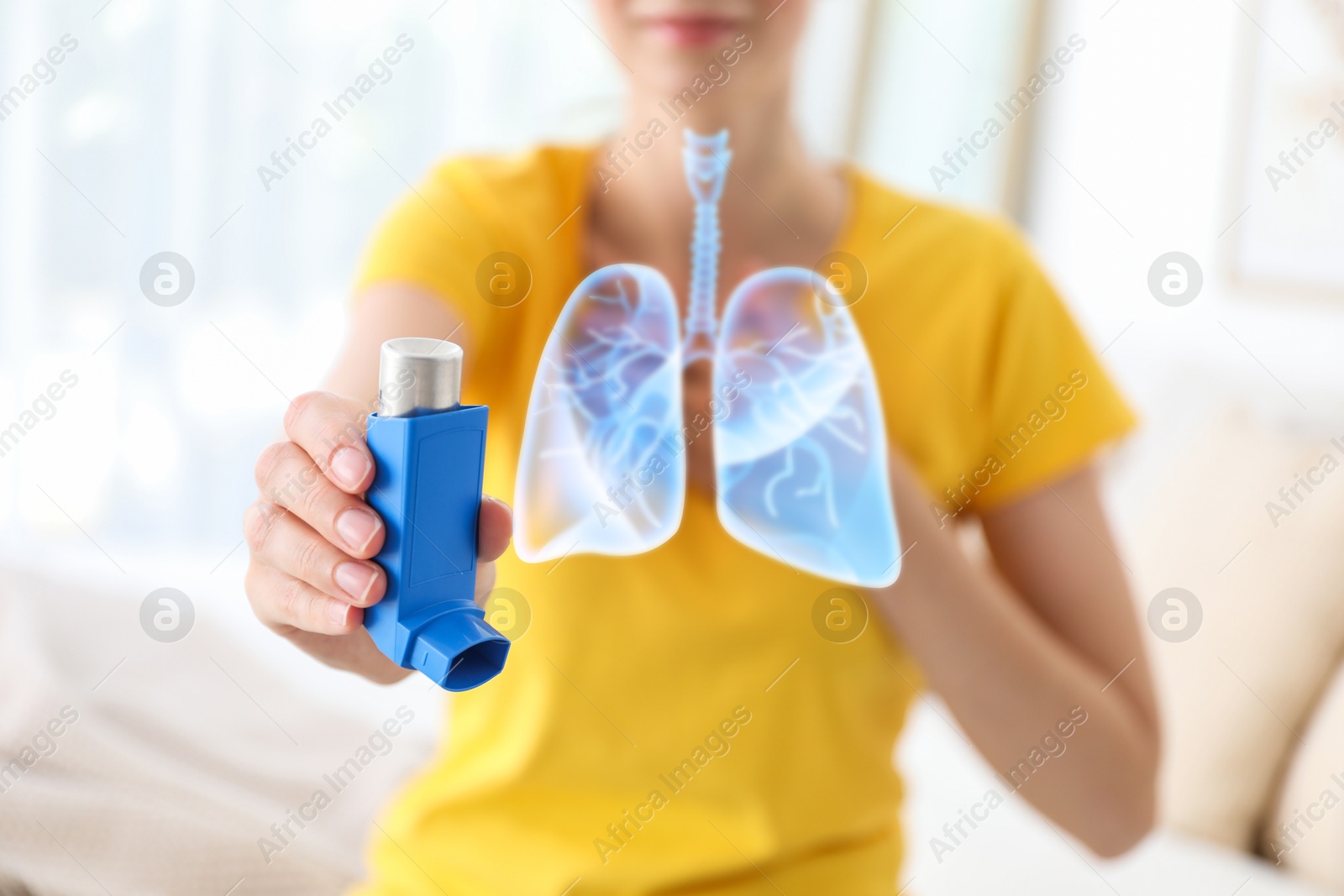 Image of Woman holding asthma inhaler indoors, selective focus. Illustration of lungs