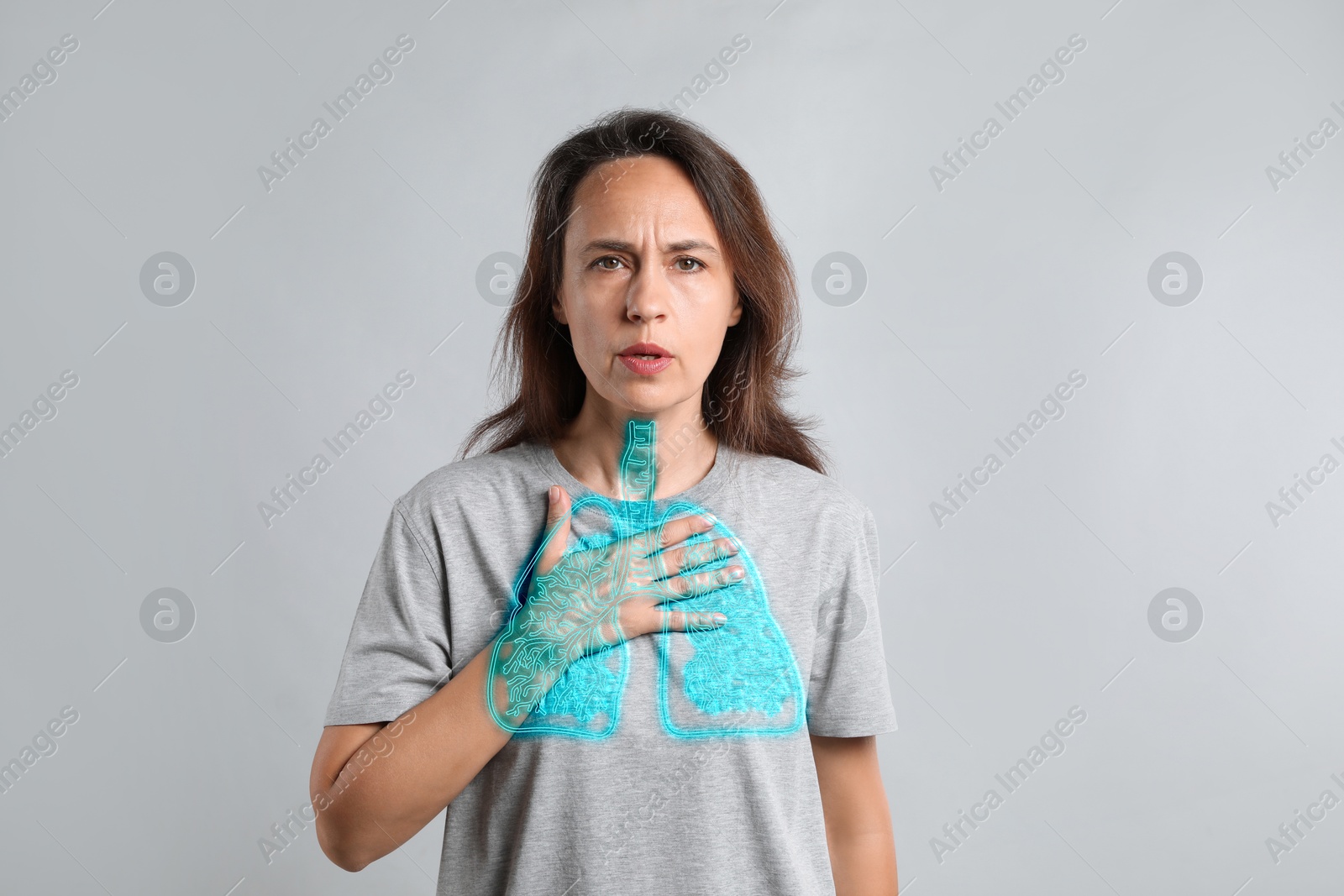 Image of Woman with asthma suffering from difficulty breathing on grey background. Illustration of lungs