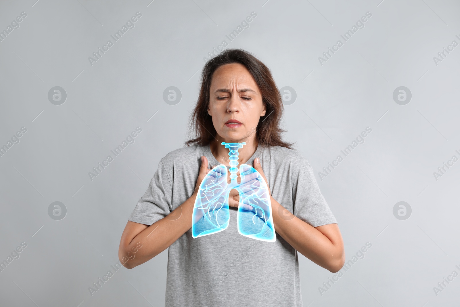 Image of Woman with asthma suffering from difficulty breathing on grey background. Illustration of lungs