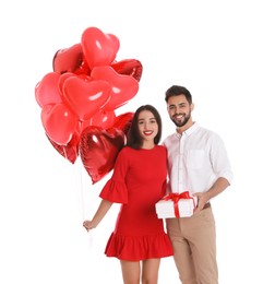 Happy young couple with gift box and heart shaped balloons isolated on white. Valentine's day celebration