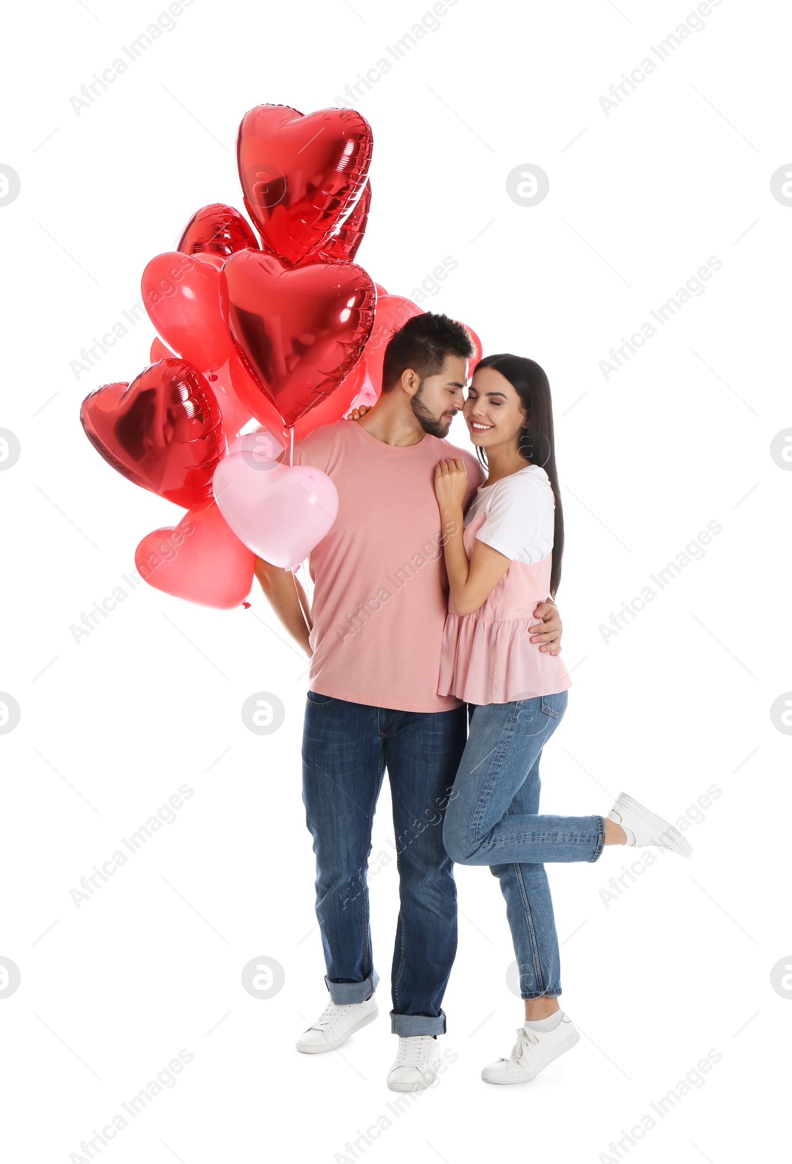 Photo of Happy young couple with heart shaped balloons isolated on white. Valentine's day celebration