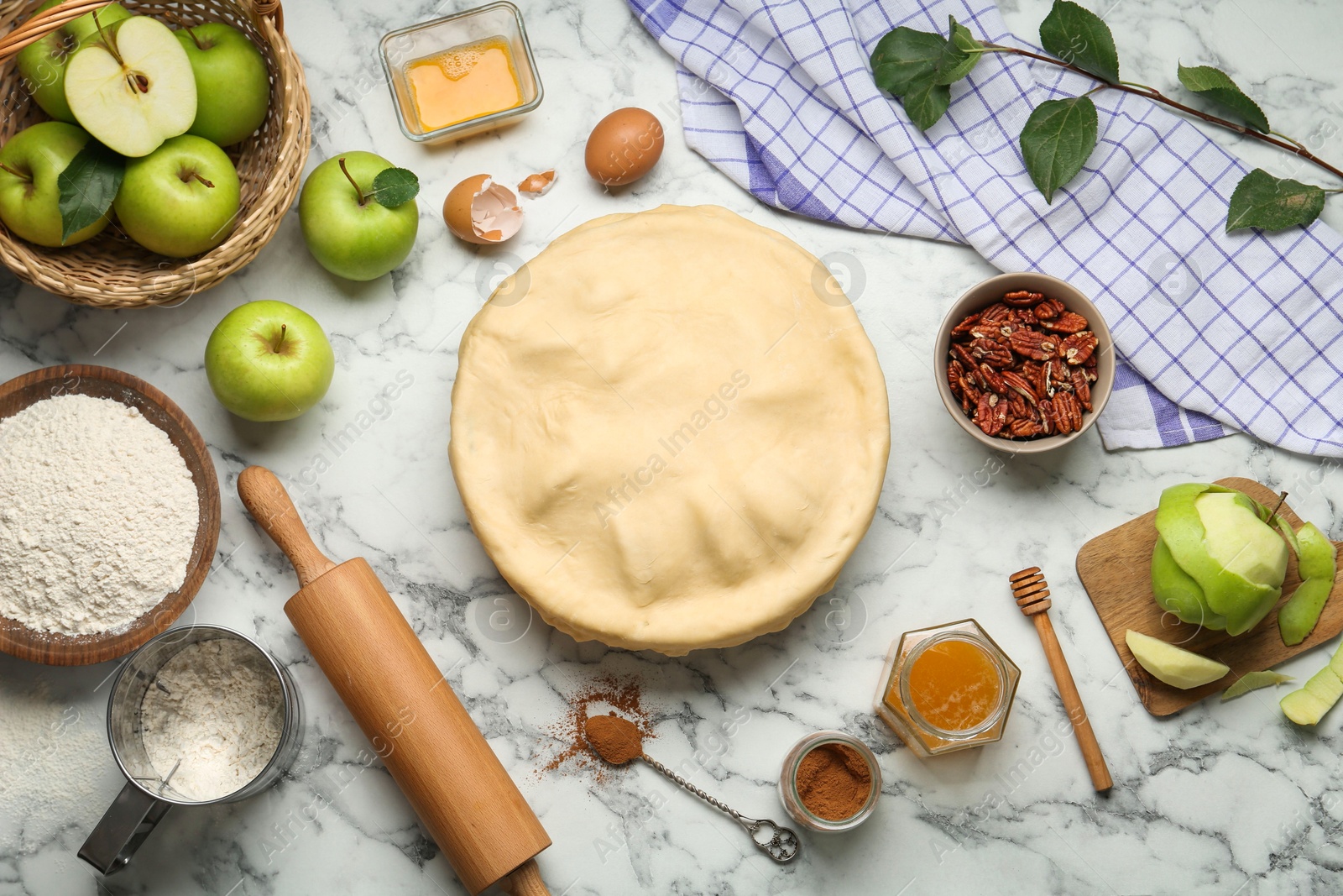 Photo of Flat lay composition with raw homemade apple pie and ingredients on white marble table