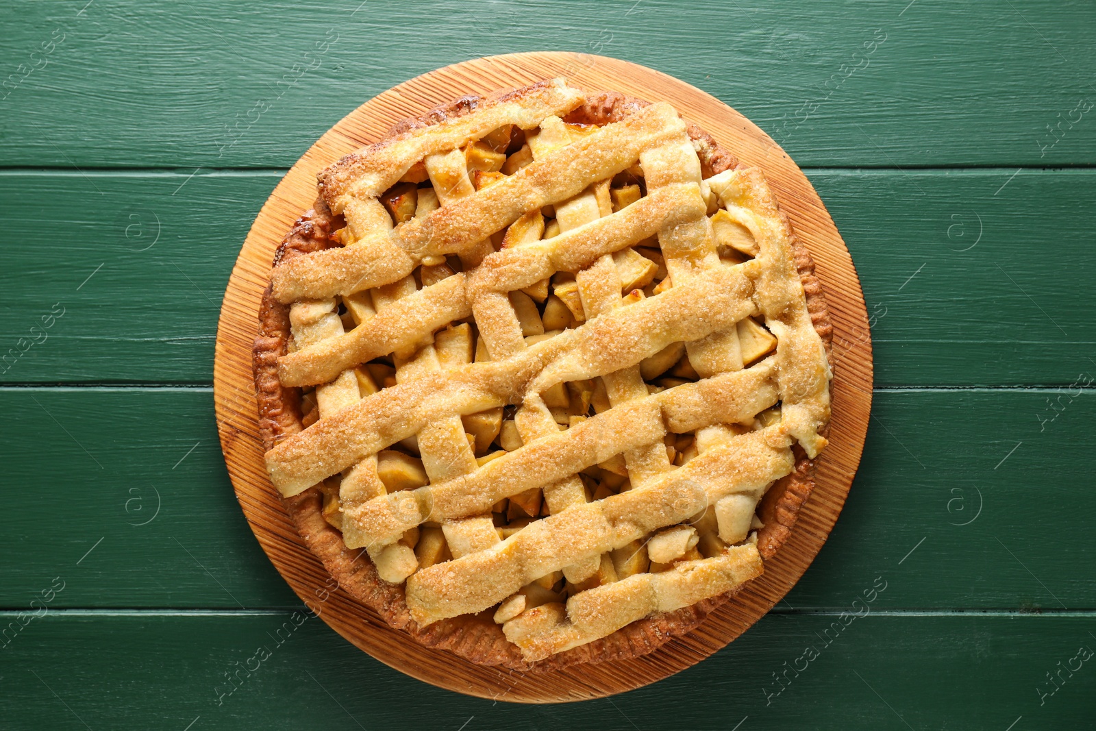 Photo of Tasty homemade apple pie on green wooden table, top view