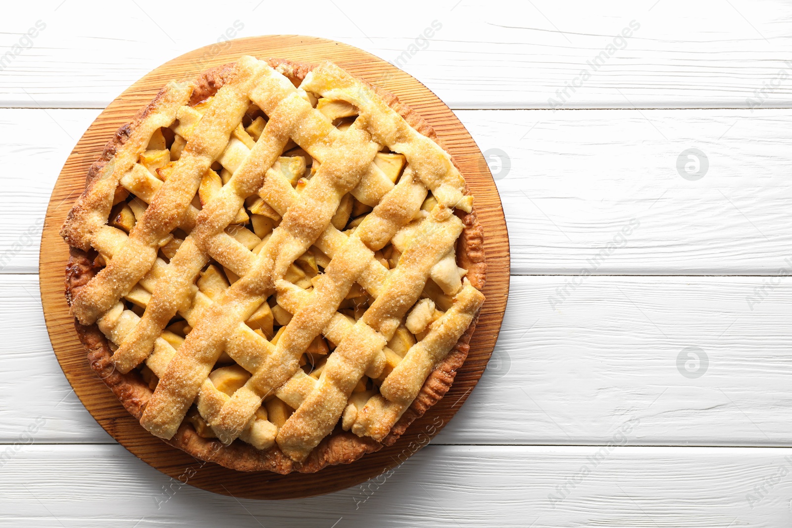 Photo of Tasty homemade apple pie on white wooden table, top view. Space for text