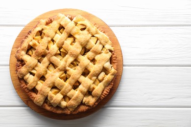 Photo of Tasty homemade apple pie on white wooden table, top view. Space for text