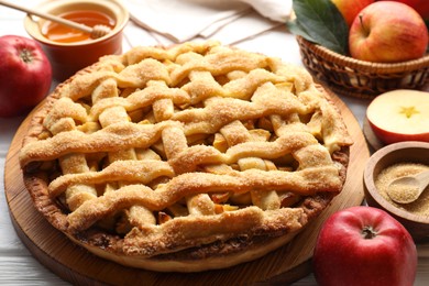 Photo of Tasty homemade apple pie and ingredients on table, closeup