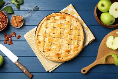 Photo of Flat lay composition with tasty homemade apple pie and ingredients on blue wooden table