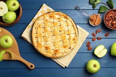 Photo of Flat lay composition with tasty homemade apple pie and ingredients on blue wooden table