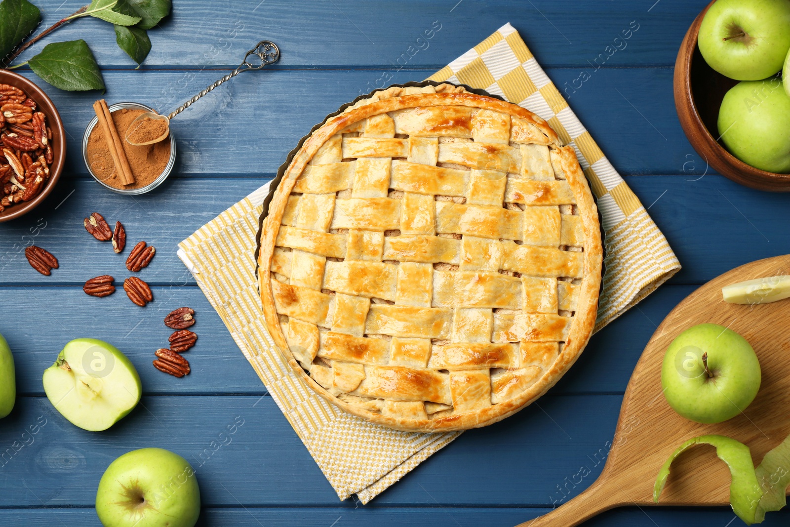 Photo of Flat lay composition with tasty homemade apple pie and ingredients on blue wooden table