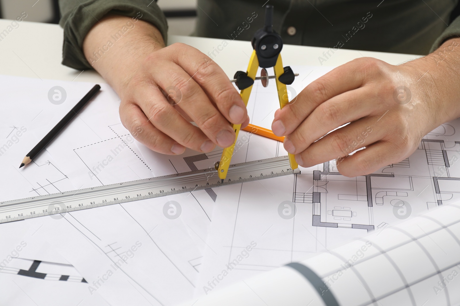 Photo of Architect working with project, closeup. Different technical drawings on table