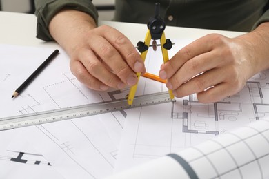 Photo of Architect working with project, closeup. Different technical drawings on table