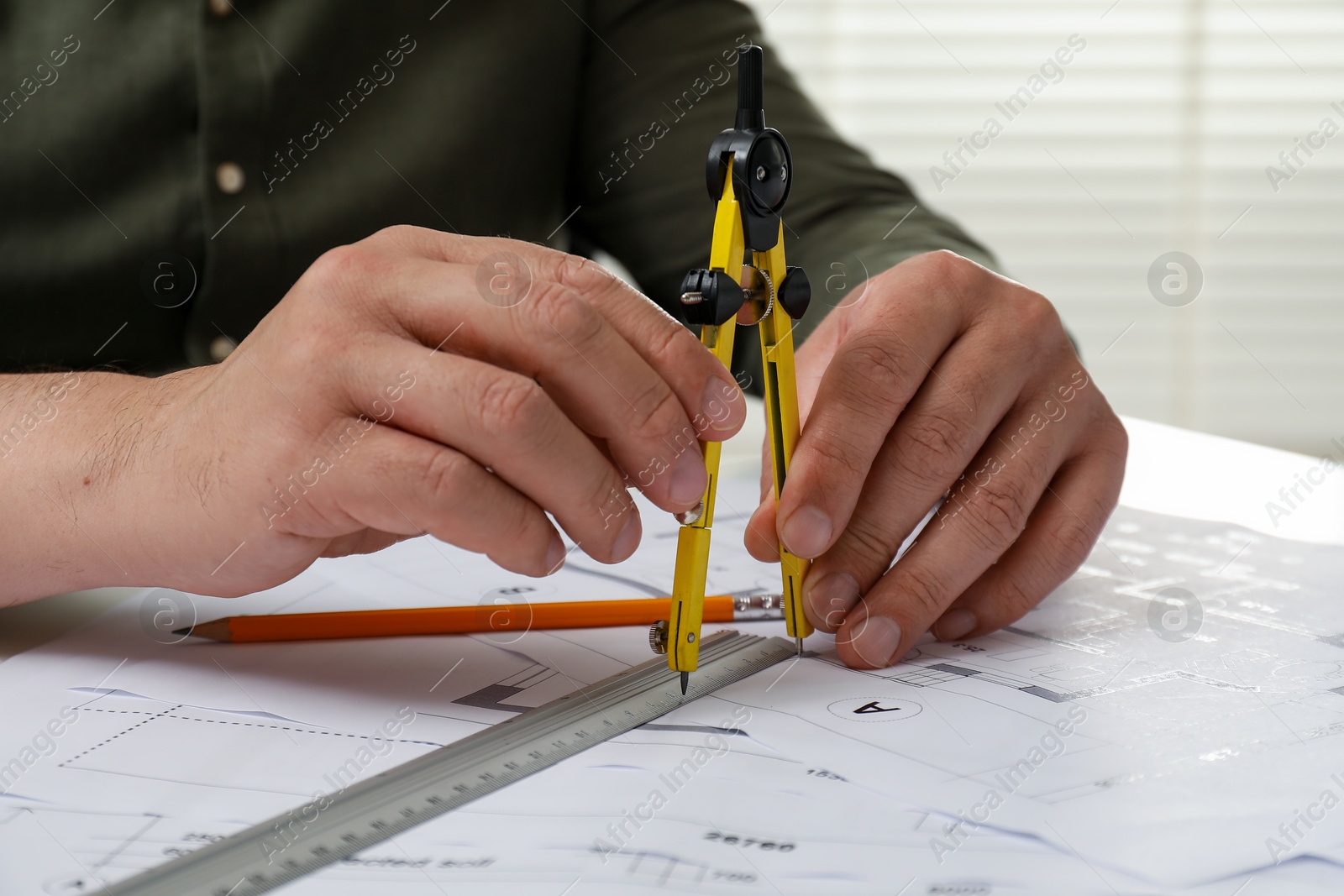 Photo of Architect working with project, closeup. Different technical drawings on table