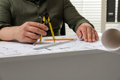 Photo of Architect working with project, closeup. Different technical drawings on table