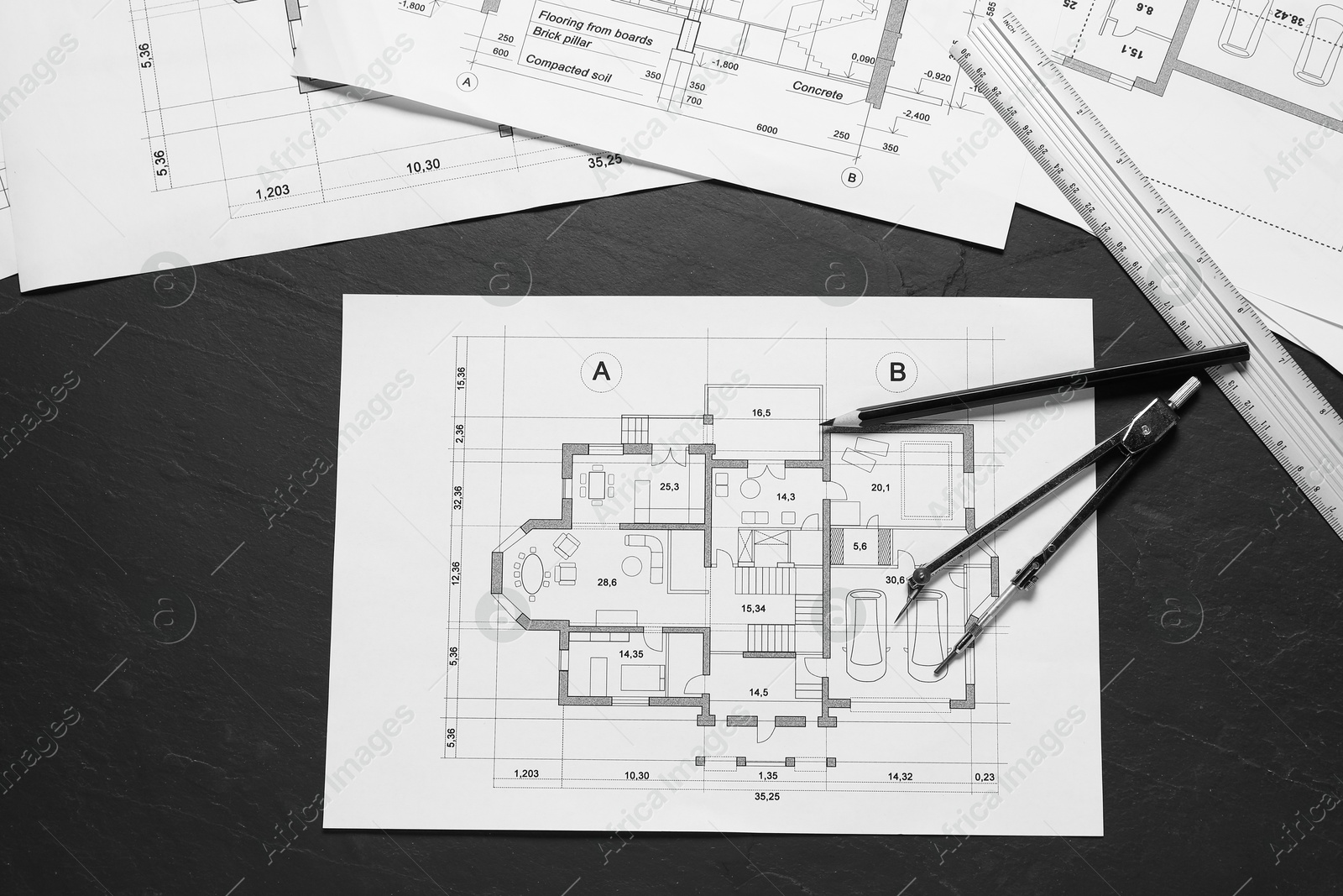 Photo of Different architectural drawings, ruler, divider and pencil on grey textured table, flat lay