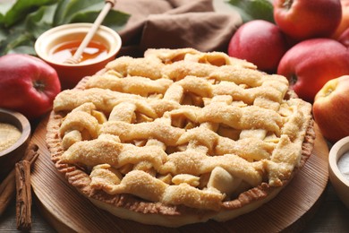 Photo of Tasty homemade apple pie and ingredients on table, closeup