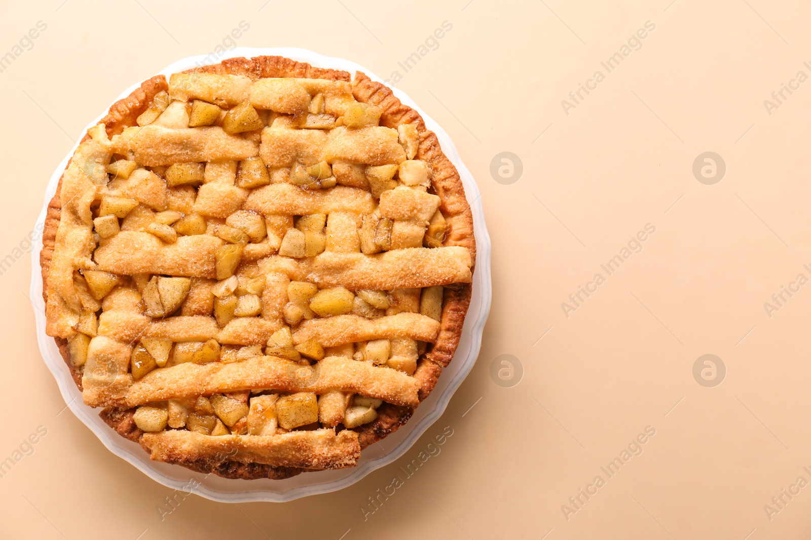 Photo of Tasty homemade apple pie on beige background, top view. Space for text