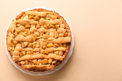 Photo of Tasty homemade apple pie on beige background, top view. Space for text