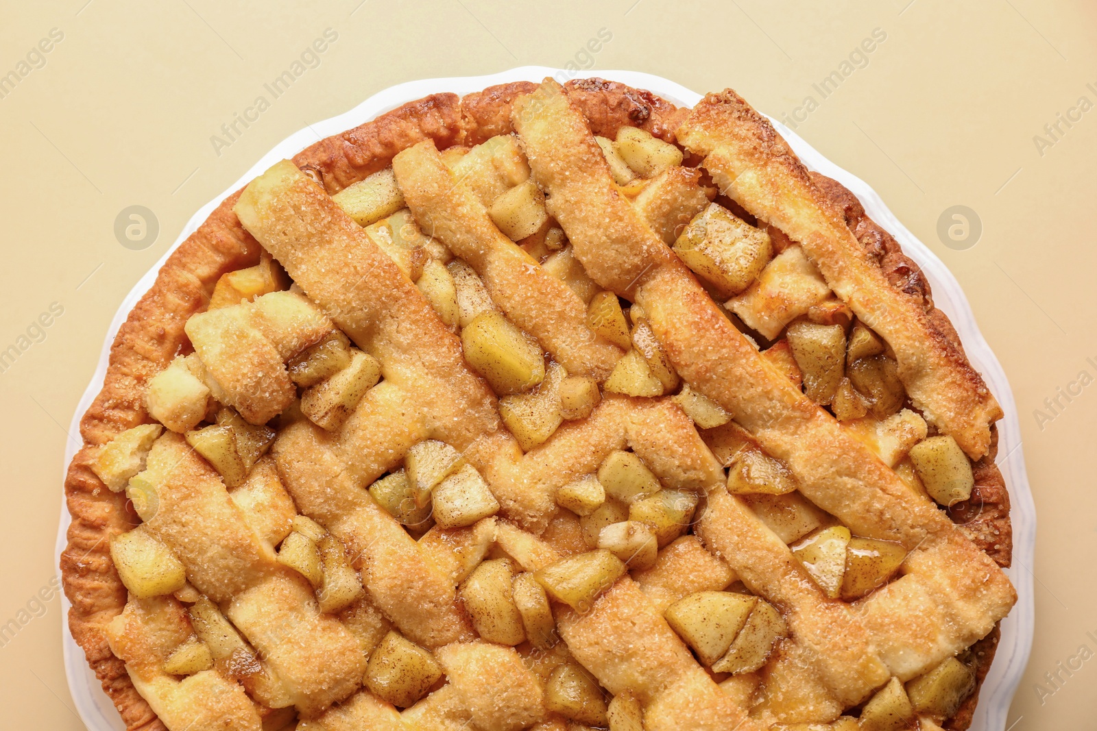 Photo of Tasty homemade apple pie on beige background, top view