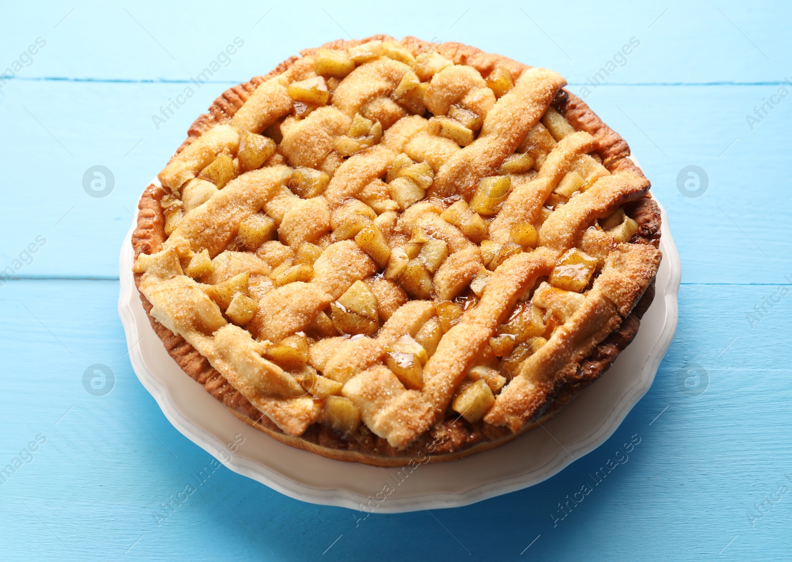 Photo of Tasty homemade apple pie on light blue wooden table