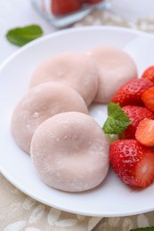 Photo of Delicious mochi and strawberries on table, closeup