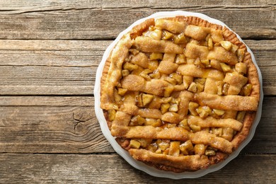 Photo of Homemade apple pie on wooden table, top view. Space for text