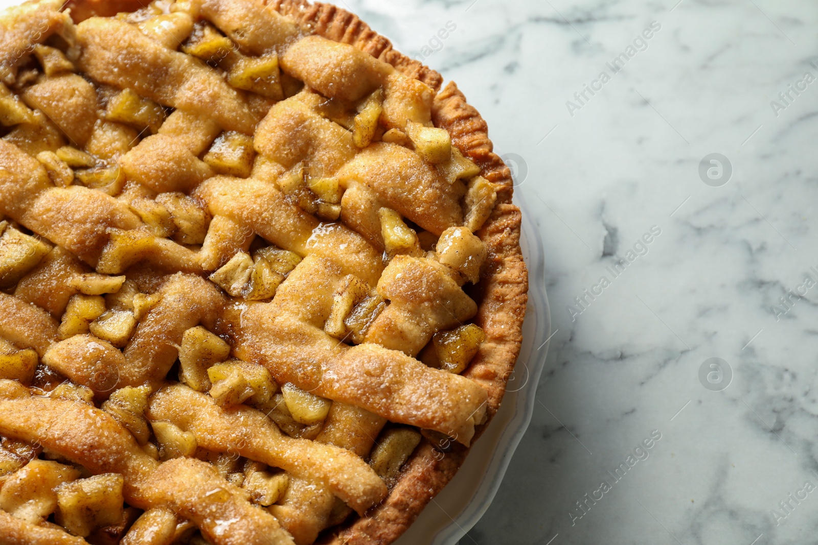 Photo of Homemade apple pie on white marble table, top view. Space for text