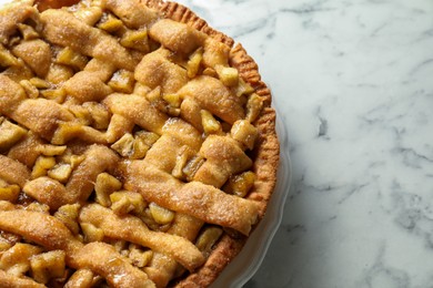 Photo of Homemade apple pie on white marble table, top view. Space for text