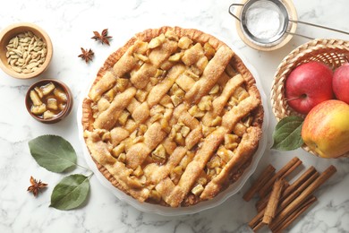 Photo of Homemade apple pie and ingredients on white marble table, flat lay