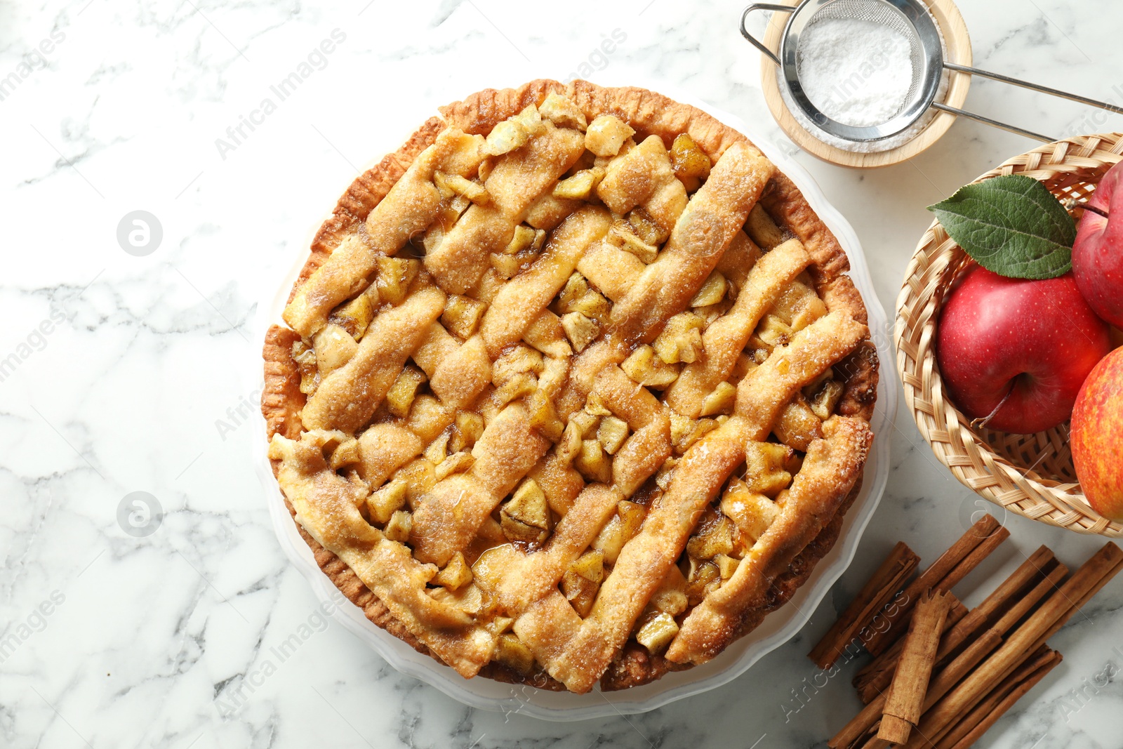 Photo of Homemade apple pie and ingredients on white marble table, flat lay