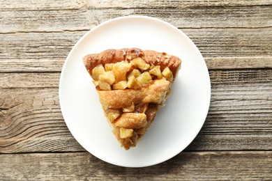 Photo of Slice of homemade apple pie on wooden table, top view