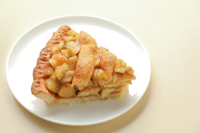 Photo of Slice of homemade apple pie on beige background, closeup